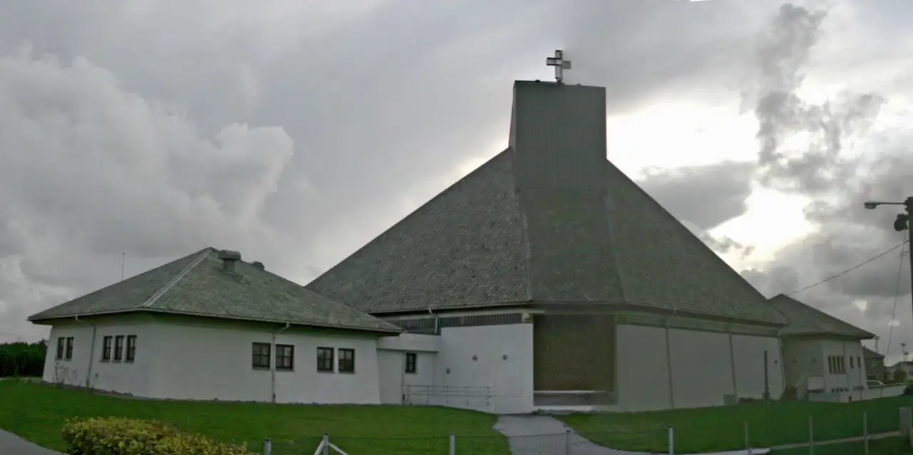 Åkra kirke i Åkrehamn sett fra sør med det store skrå taket og sidebyggene.