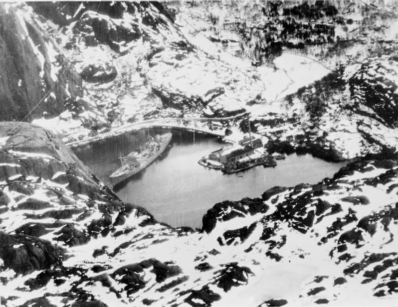 Altmark ligger inne i Jøssingfjord vinteren 1940 omgitt av snødekte fjell før britiske styrker bordet skipet.
