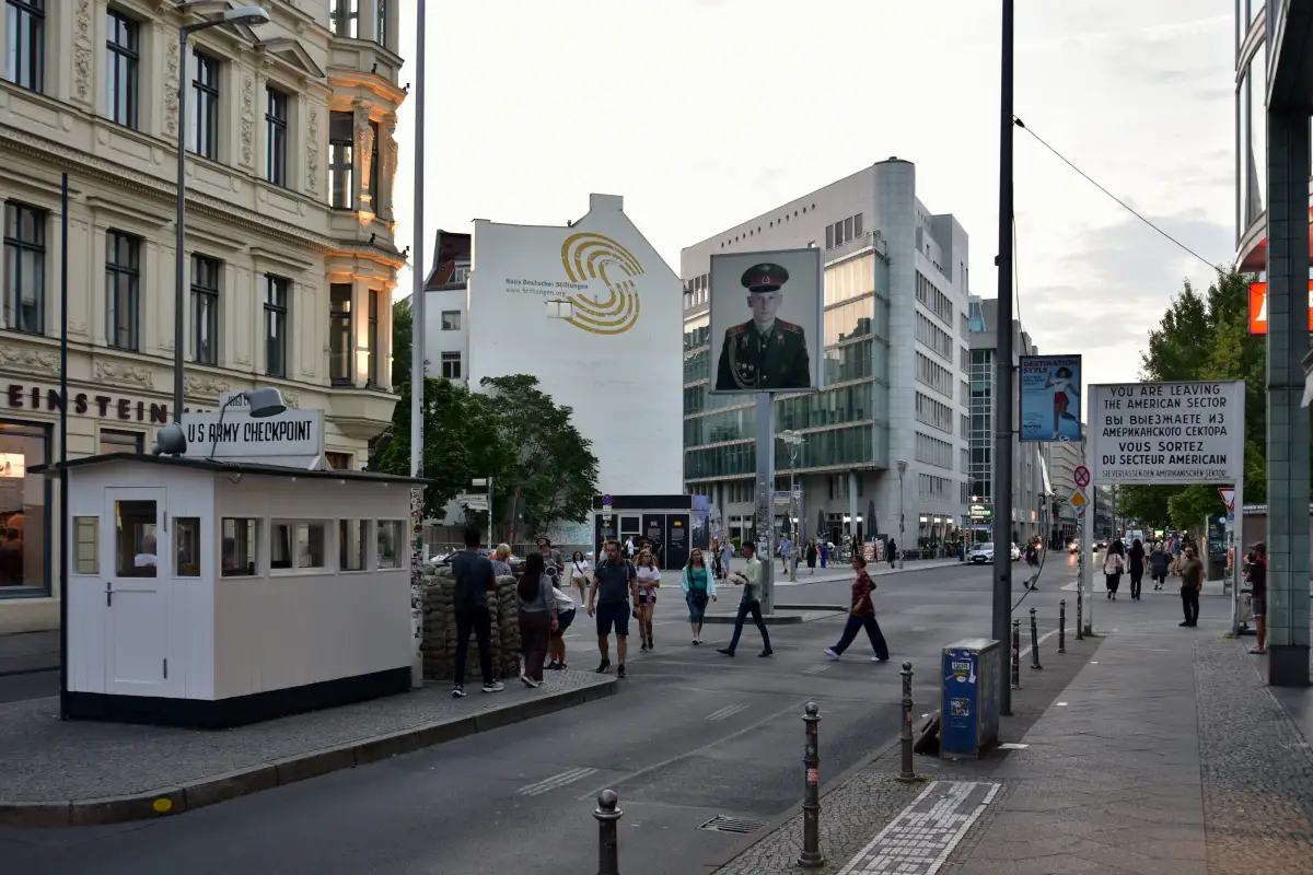 Checkpoint Charlie i Berlin med den ikoniske vaktboden, turistbesøkende og skiltet som markerer grensen mellom den tidligere amerikanske og sovjetiske sektoren.