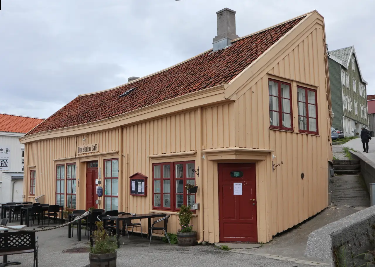 Dødeladen på Innlandet i Kristiansund med uteservering og bratt gate ved siden av bygget.