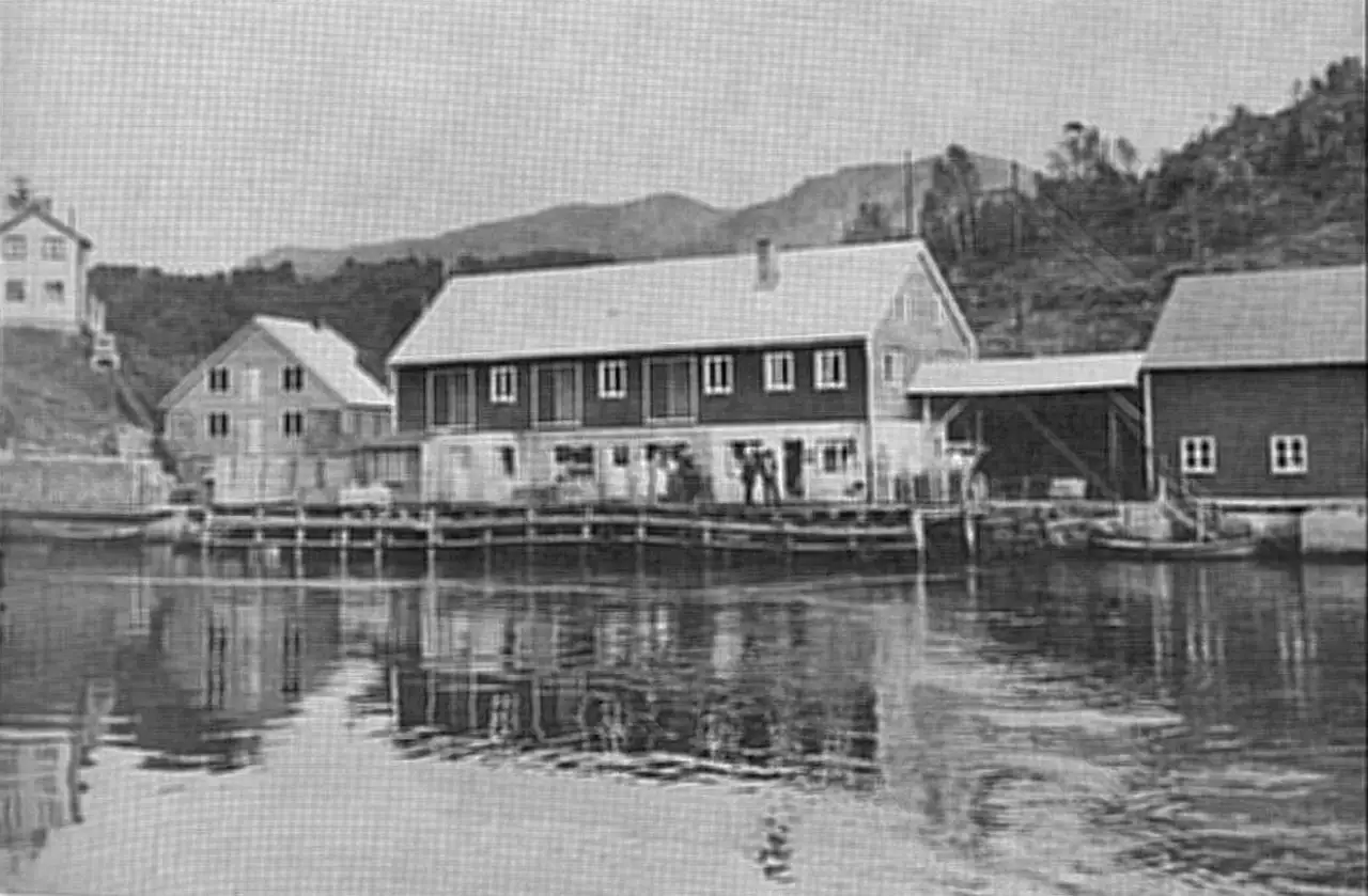 Gjølanger med kaianlegg og trebygninger langs fjorden fotografert rundt 1951.