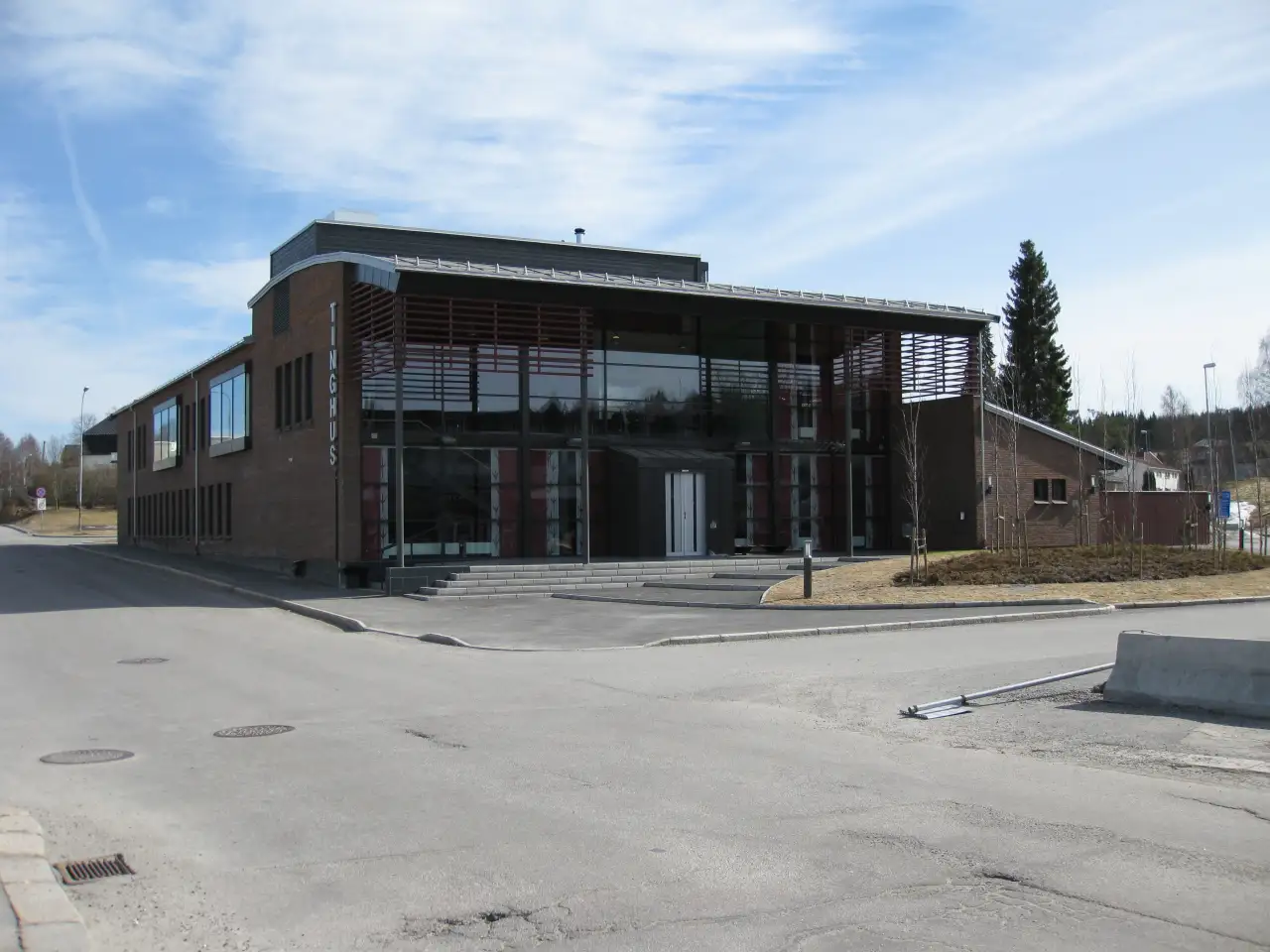 Glåmdal tingrett i Kongsvinger, moderne rettsbygg i mur og glass ved innkjøringen til sentrum.