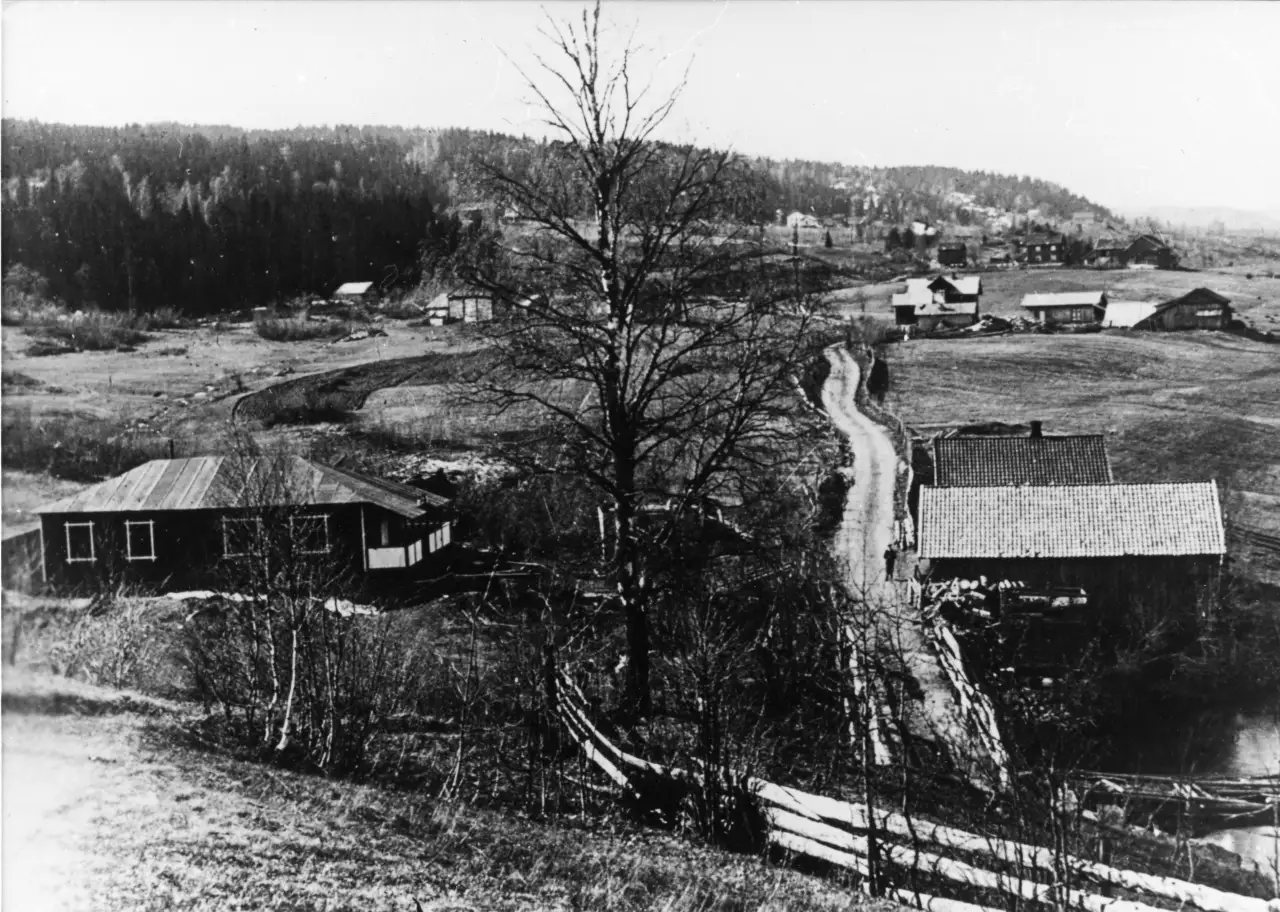 Hillestad ved Heistadmoen i 1912 med gårder, åkerlandskap og brua over Dalselva i forgrunnen.