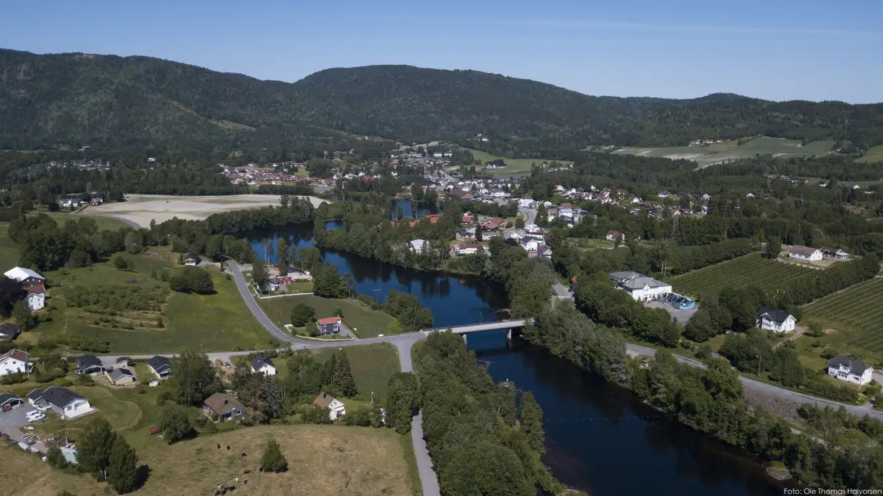Hvittingfoss sett fra luften med Numedalslågen, broer og tettstedets sentrum omgitt av åser.