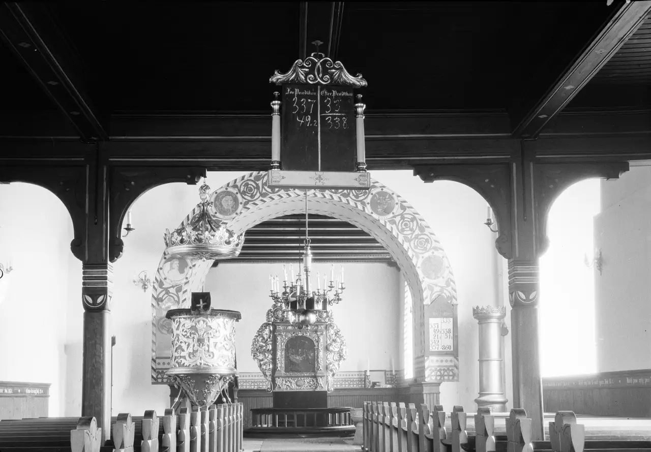 Historisk interiør av Trøgstad kirke med altertavle, korbue og prekestol