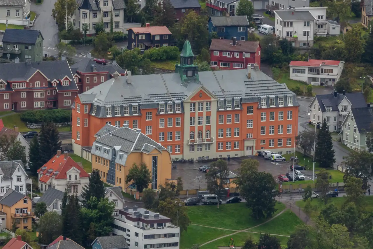 Kongsbakken videregående skole sett fra høyden omgitt av bolighus og grøntområder i Tromsø sentrum.