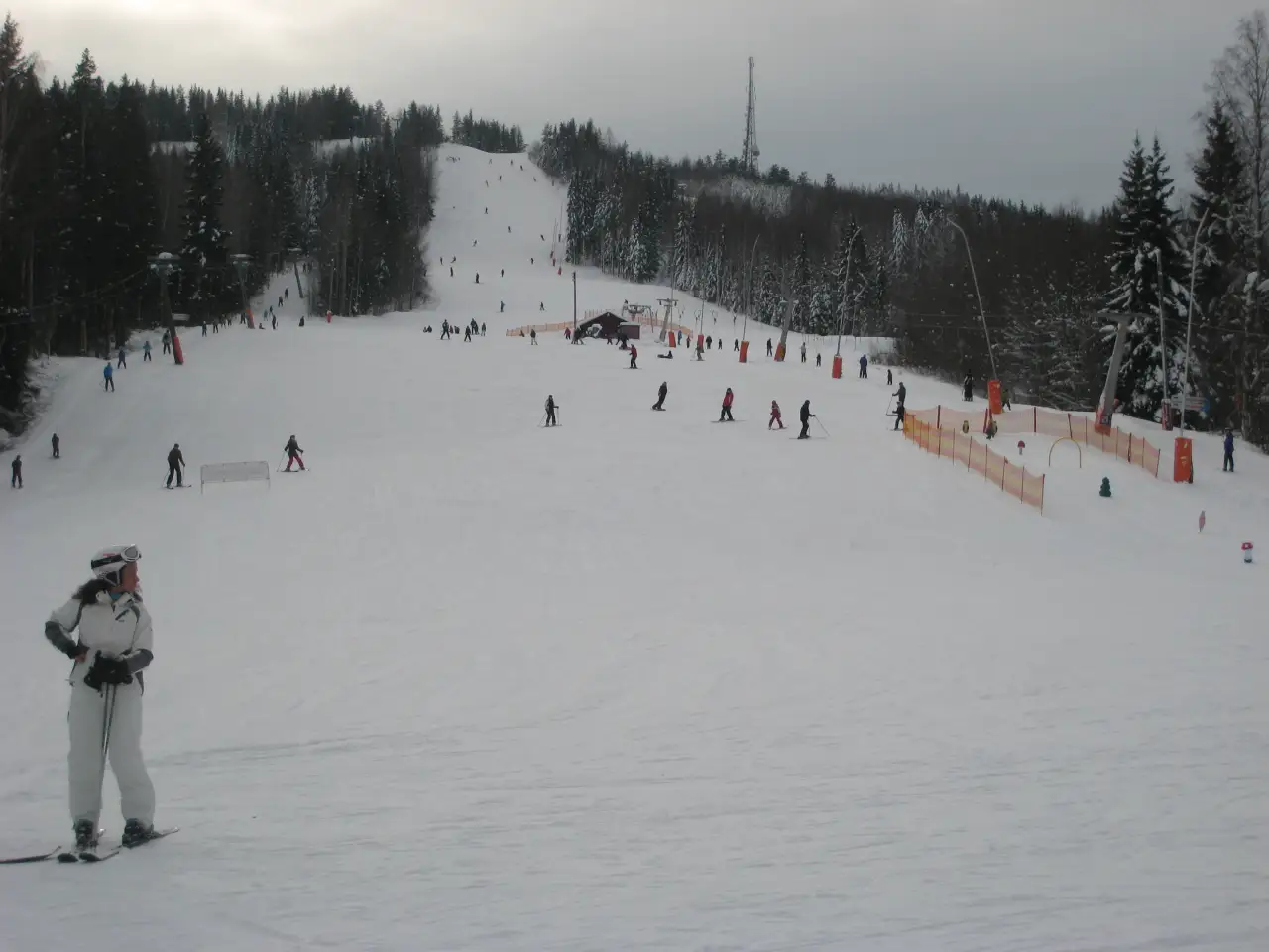 Kongsberg Skisenter med bred hovedbakke der mange kjører ski en vinterdag.
