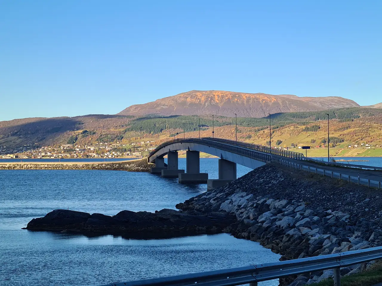 Kveøybrua sett fra Hinnøya med Borkenes og Rødmoldheia i bakgrunnen i høstlys.