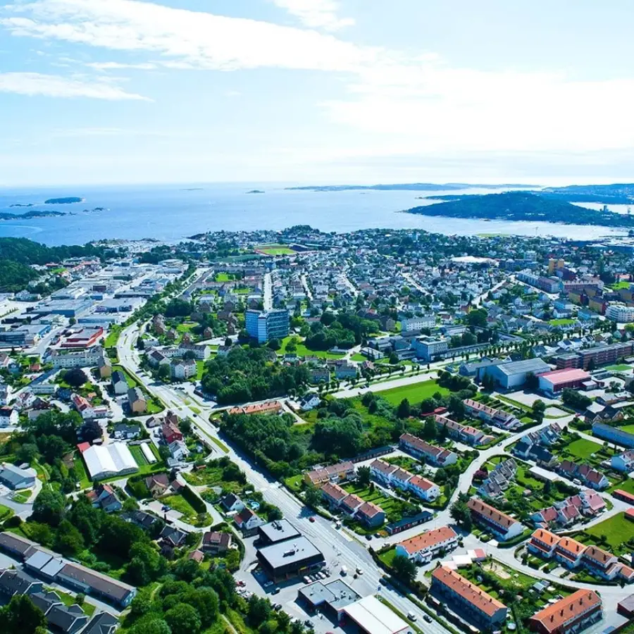 Luftfoto av Lund i Kristiansand med boligområder og utsikt mot kysten.