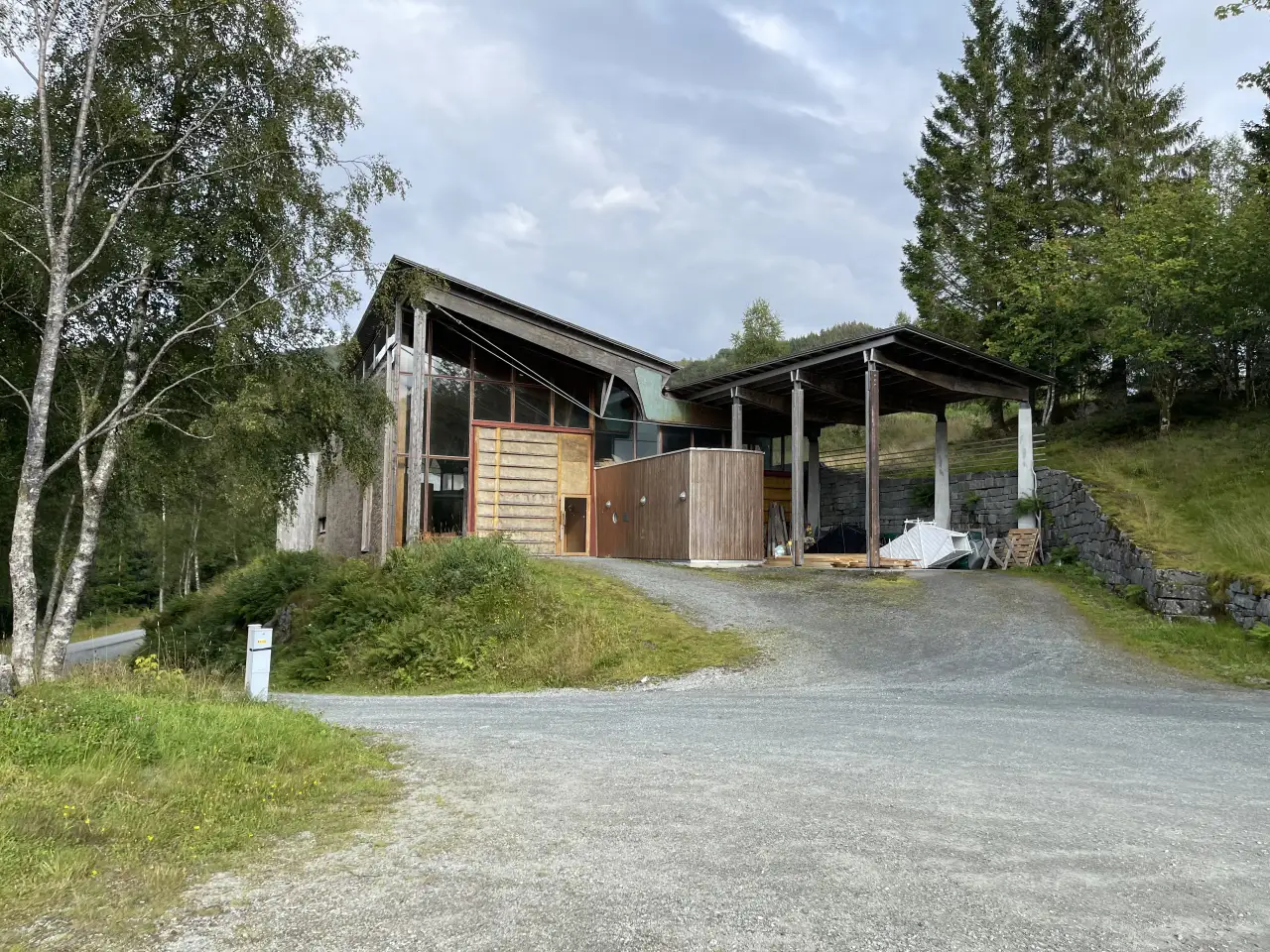 Nordisk Kunstnarsenter Dale på Dalsåsen med det åpne trebygget som står like ved skogkanten over Dale.