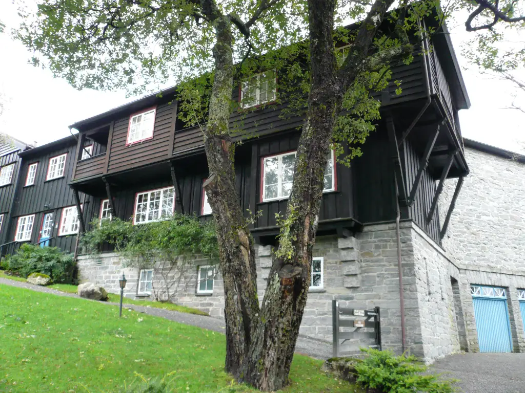 Siljustøl i Rådal med trebygning og steinfundament omgitt av hage i Bergen.