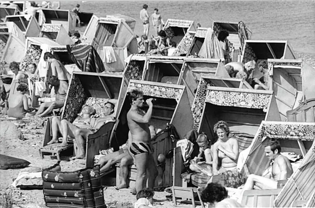 Folk sitter i strandkurver på stranden i Börgerende under en sommerdag ved Østersjøen.