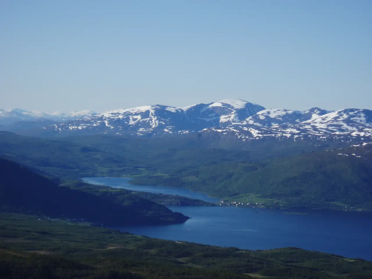 Straumsbotn og Sætertinden sett fra Raudmoldheia med fjord, grønne dalsider og snødekte fjelltopper.