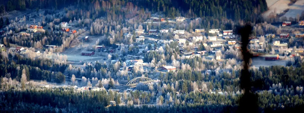 Svene sett ovenfra med vinterlys over husene og brua som krysser Numedalslågen.