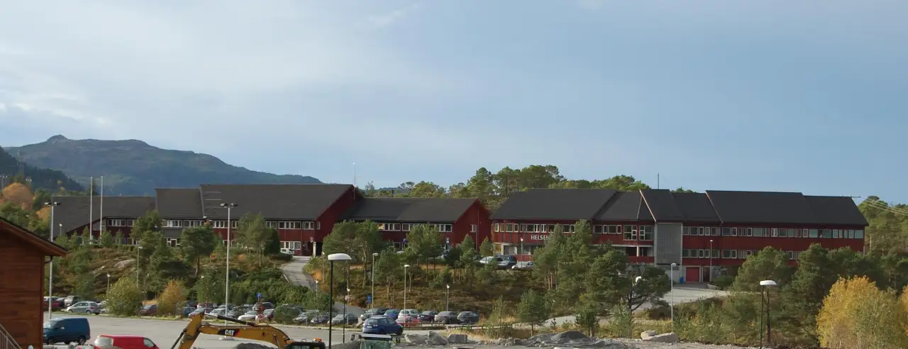 Tidligere Frei rådhus på Rensvik med fjellandskap i bakgrunnen.