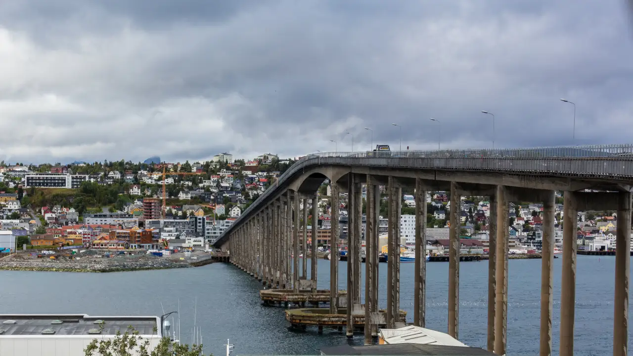 Tromsøbrua sett mot Tromsdalen med boliger og havområdet under brua.