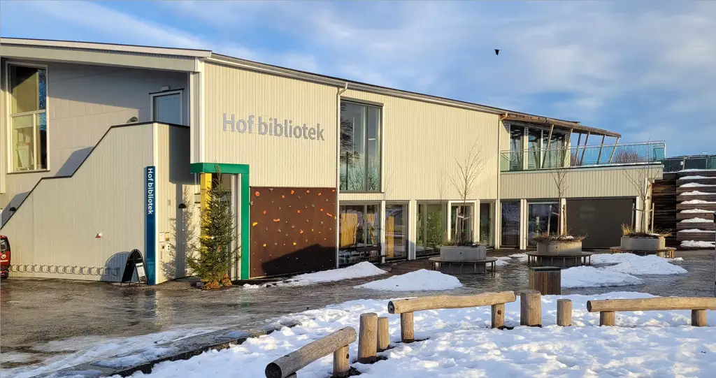 Hof bibliotek i Vestfold med lyse fasader snø på bakken og uteområde foran bygget.