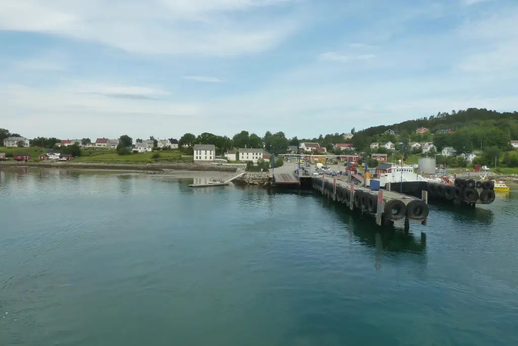 Fergekai på Tjøtta med kai, ferje og bebyggelse langs sjøen