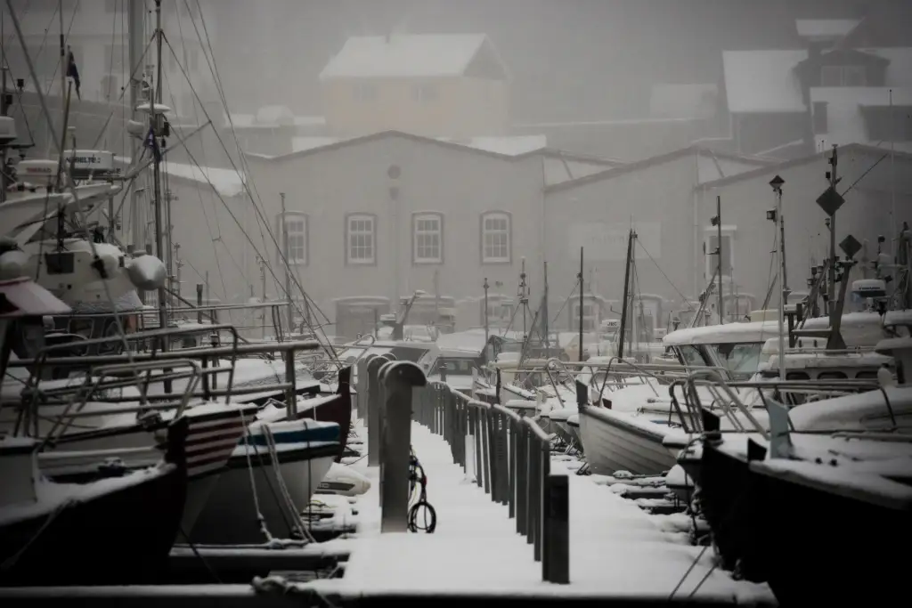 Vågsbotn småbåthavn i Åsane med snødekte brygger og båter.