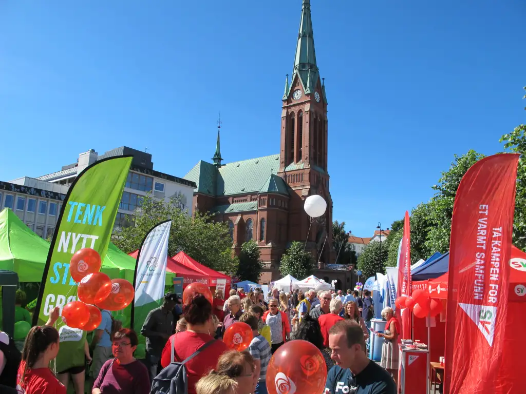 Folkeliv og stands under Arendalsuka i Arendal sentrum med Trefoldighetskirken i bakgrunnen.