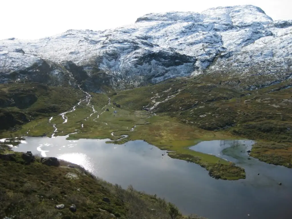 Finnabu stølsområde i Sauda med vann myr og snøflekker i høyfjellslandskap