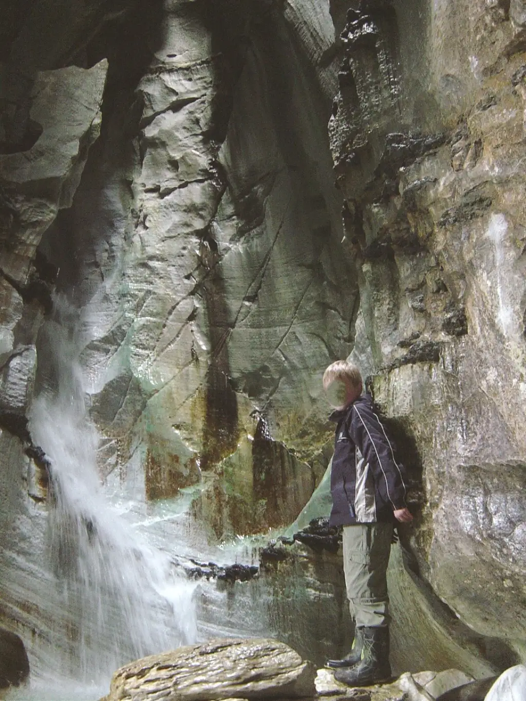 Foss inne i Trollkirka med høye grottevegger og rennende vann.