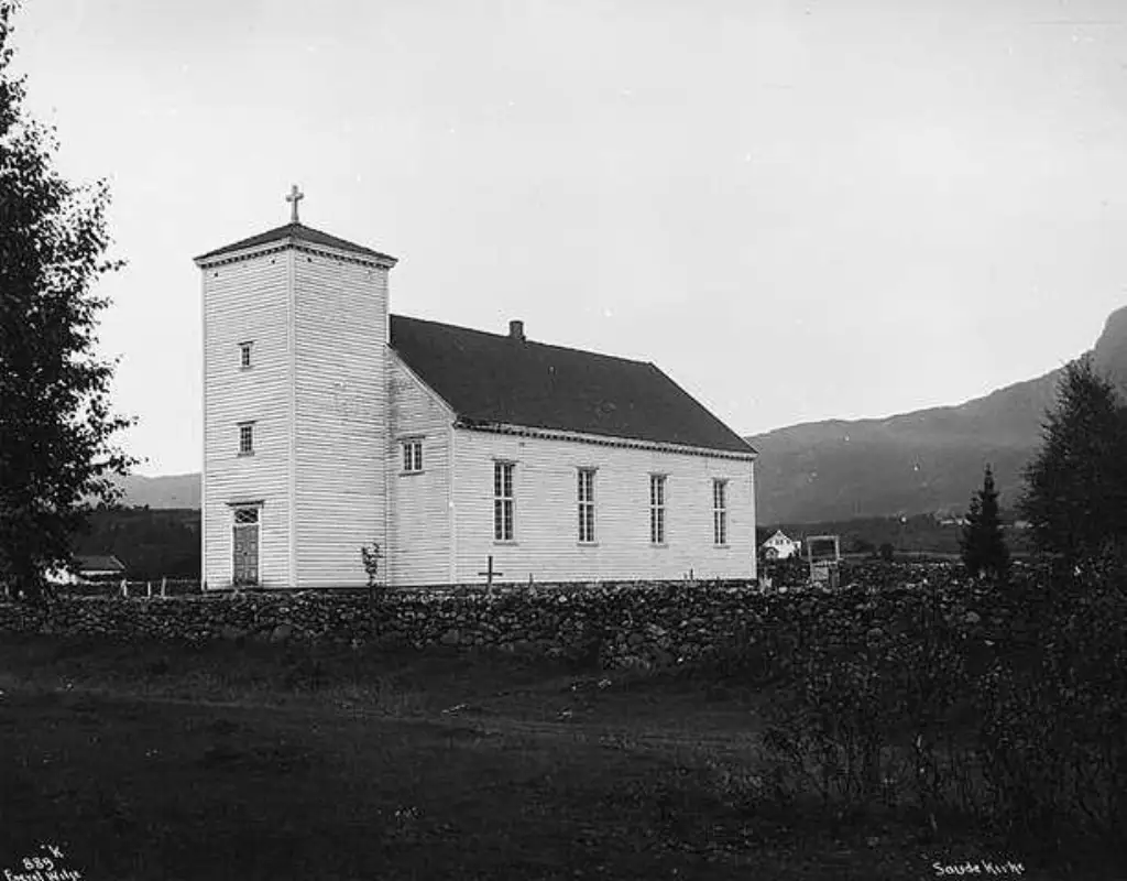 Sauda kirke i 1913 omgitt av steingard og åpent landskap før industribygging