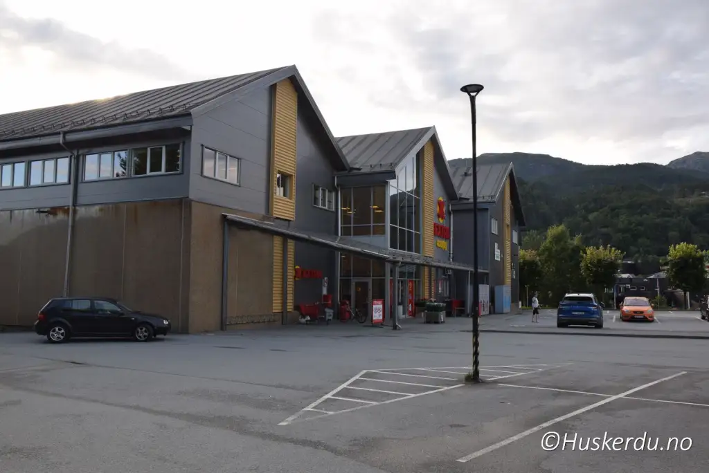 Sauda sentrum med butikker og fjell i bakgrunnen