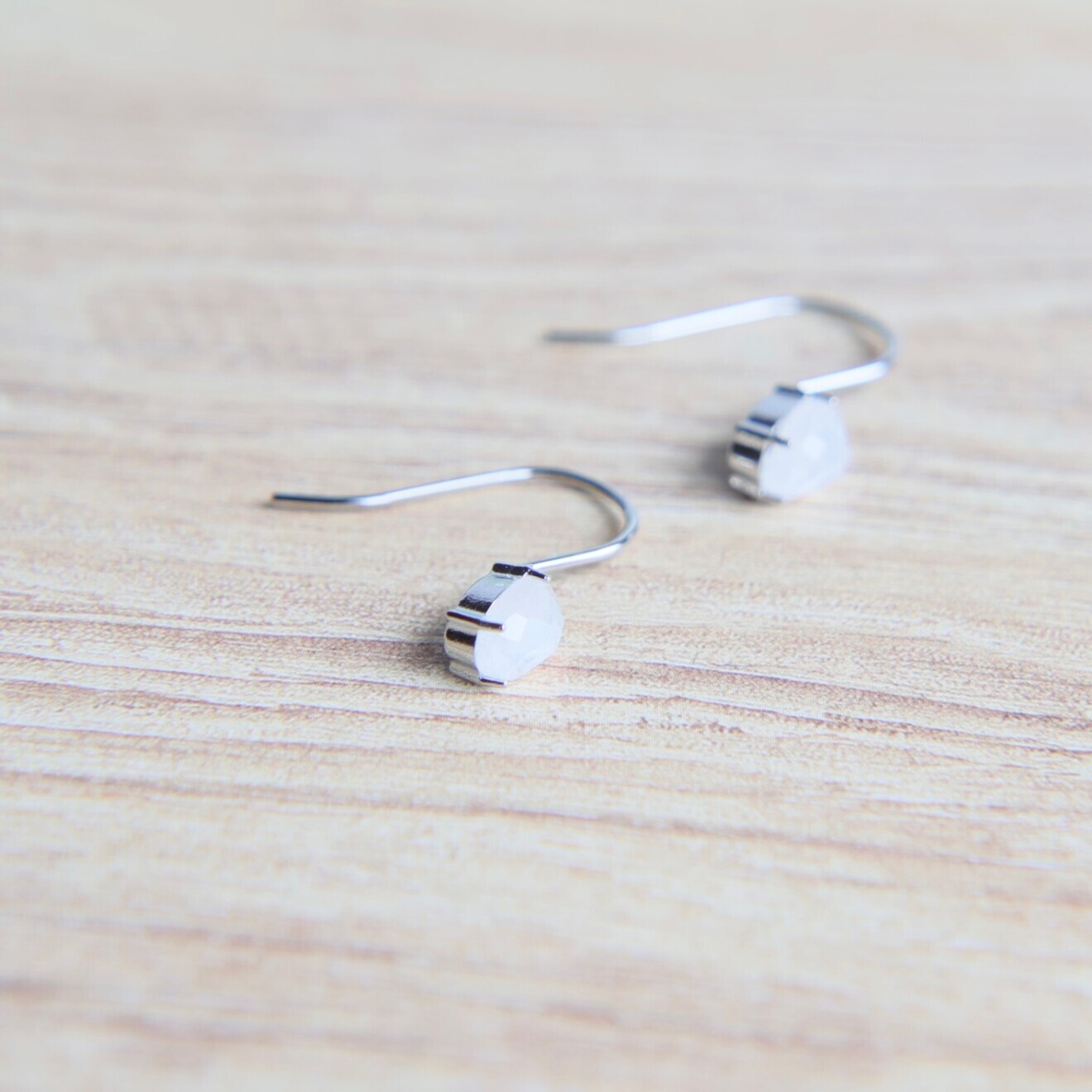 青く煌めく揺れるピアス ― レインボームーンストーン フックピアス