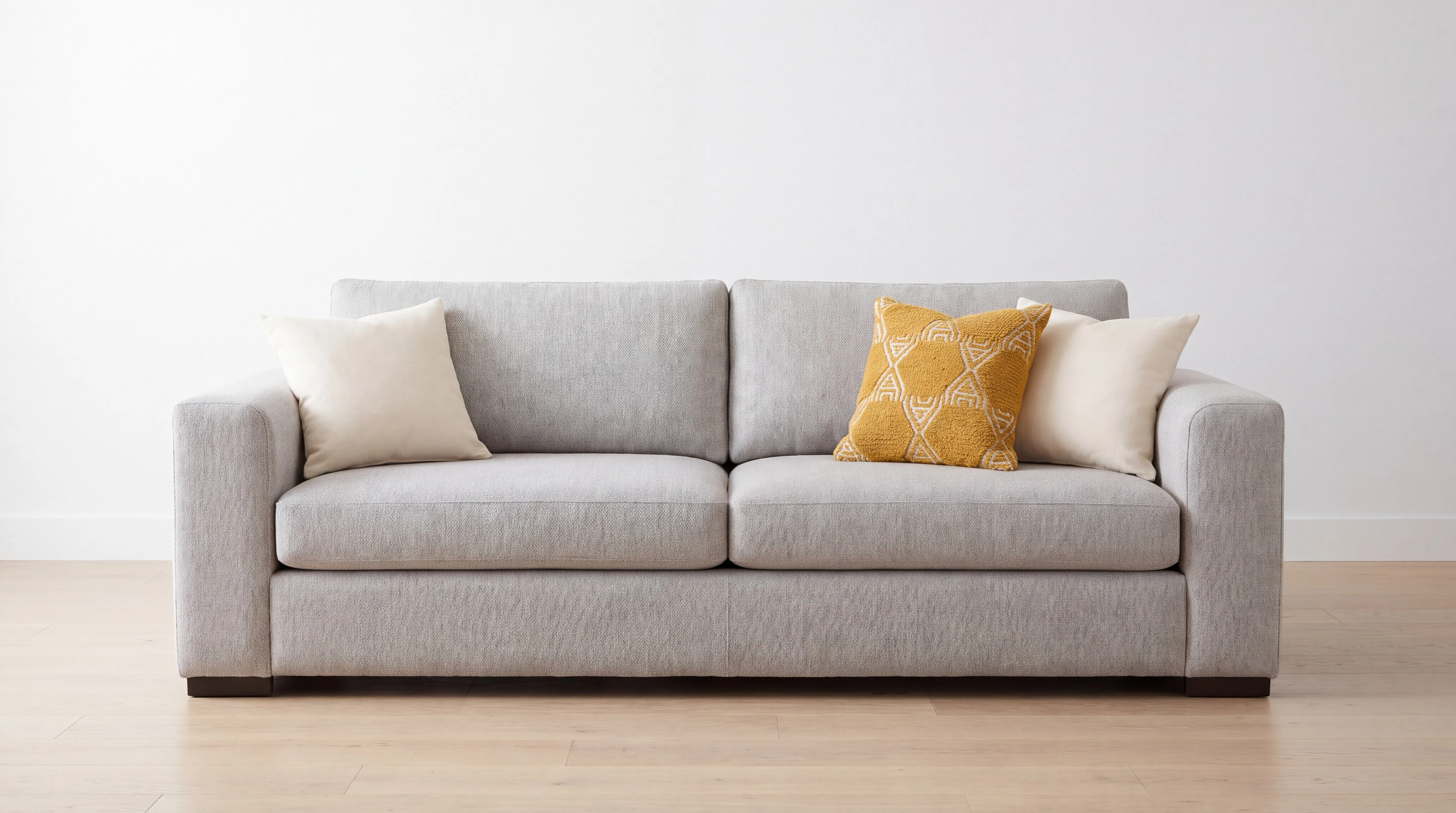An ecommerce photo of a gray sofa with three throw pillows