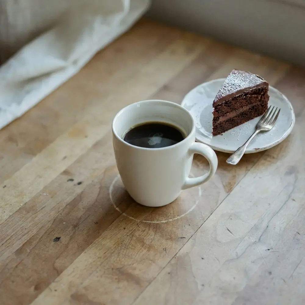 The mug with a slice of cake beside it