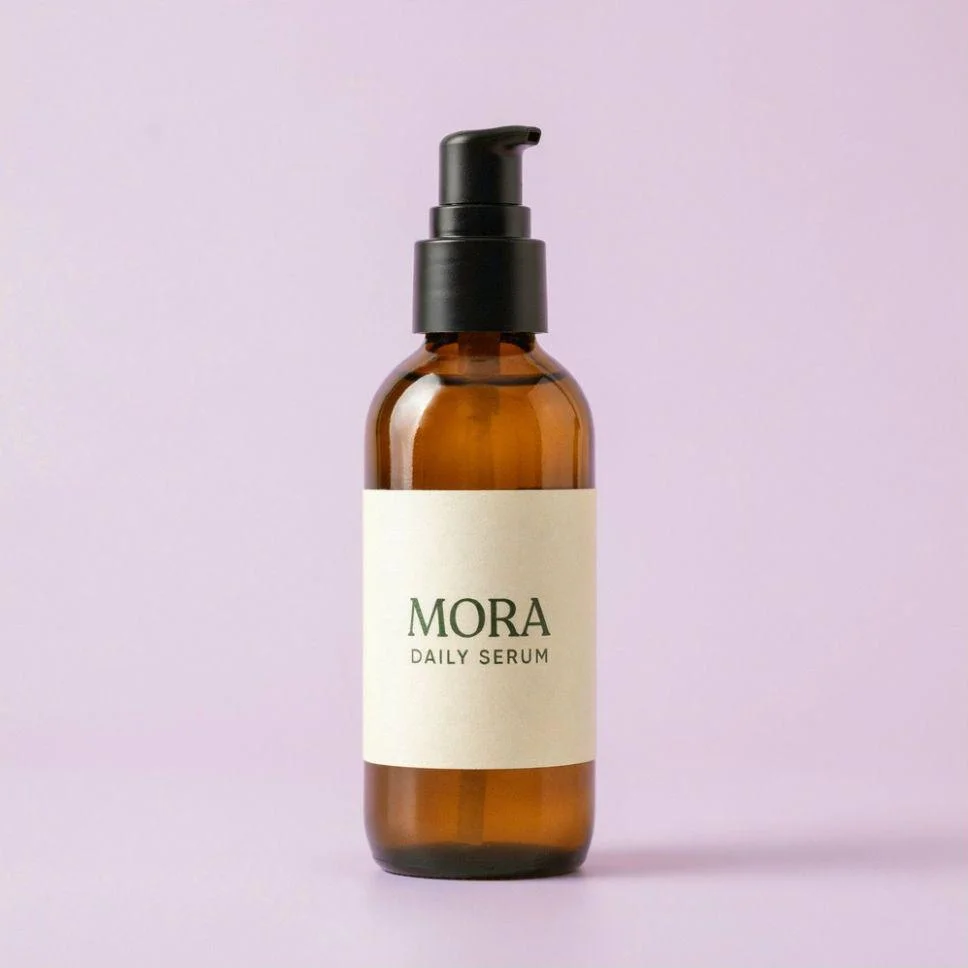 The same MORA Daily Serum bottle and label on a pale lilac background.