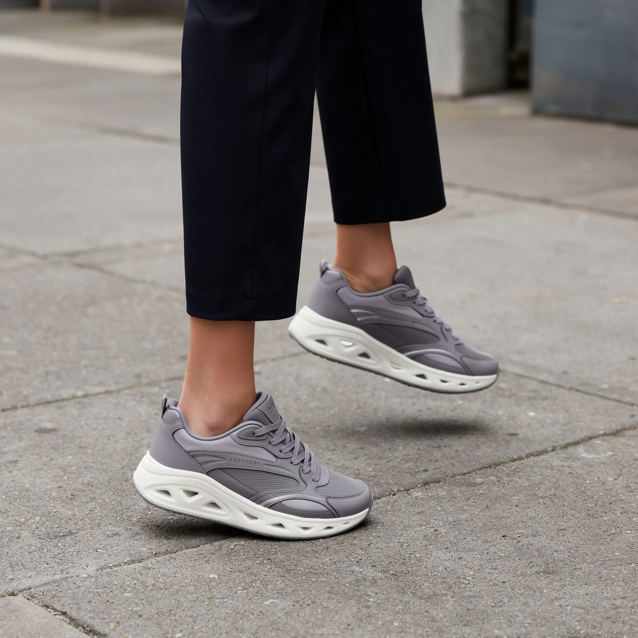 A walking figure in grey trainers whose tongue label text is blurred