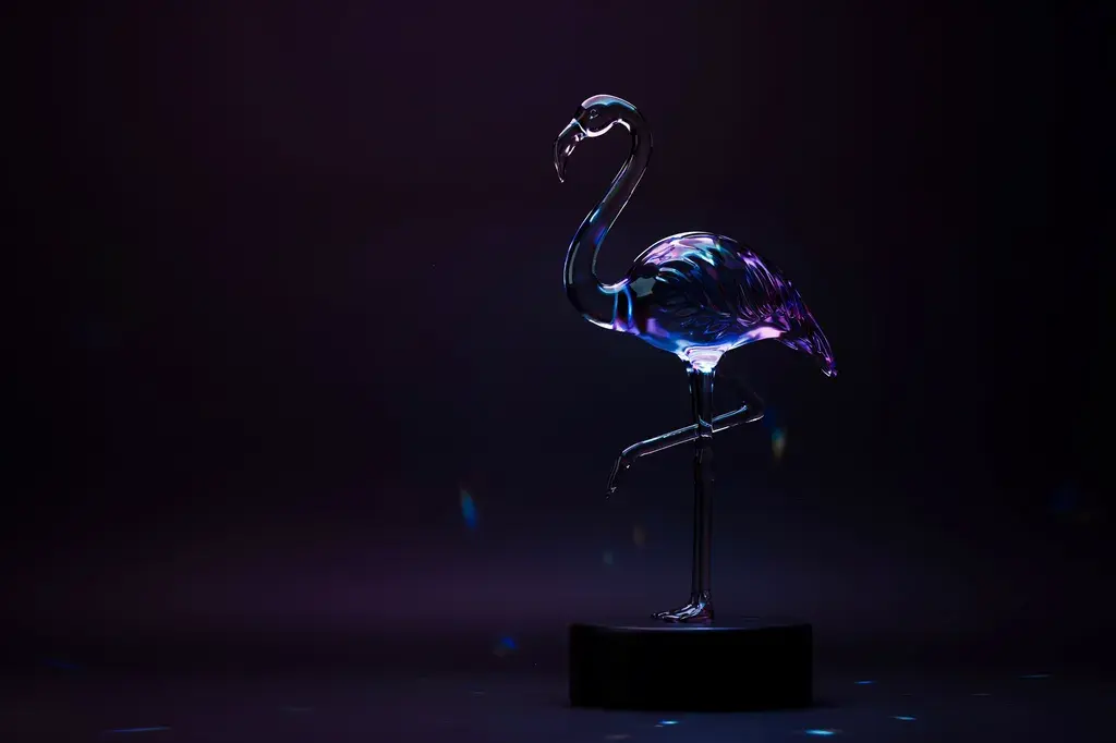 Iridescent glass flamingo sculpture lit in cool amethyst and ice blue tones