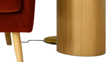 A close-up of Ideogram's cutout with the chair leg, the lamp cord, the round lamp base, and the side table.