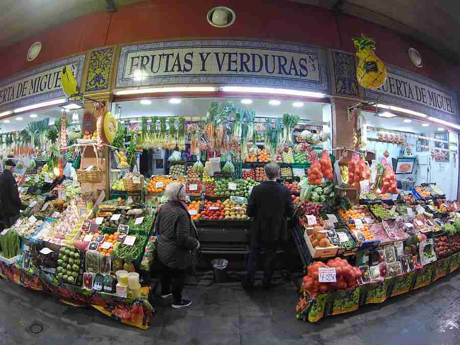 Vemos un puesto de mercado, con frutas y vegetales.