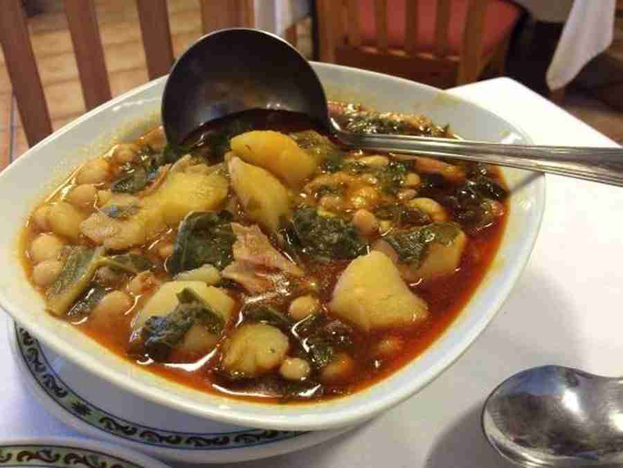 Una fuente con un cocido con habas, verduras y carnes, uno de los 5 Platos Fuertes de la Cocina Asturiana