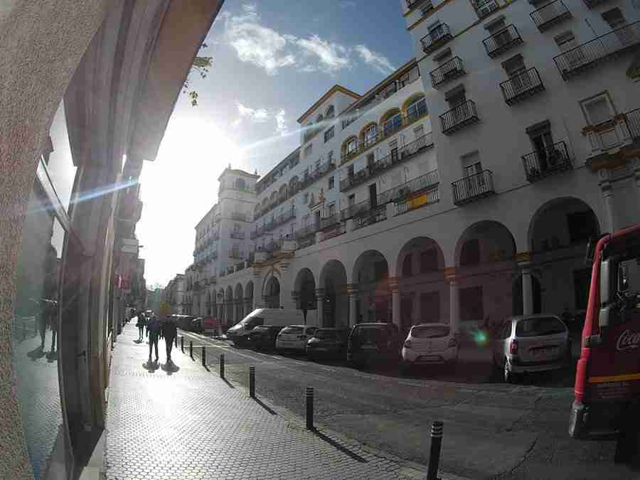 Vemos la fachada principal del mercado del Arenal, en Sevilla, un edificio blanco, grande y con arcadas.