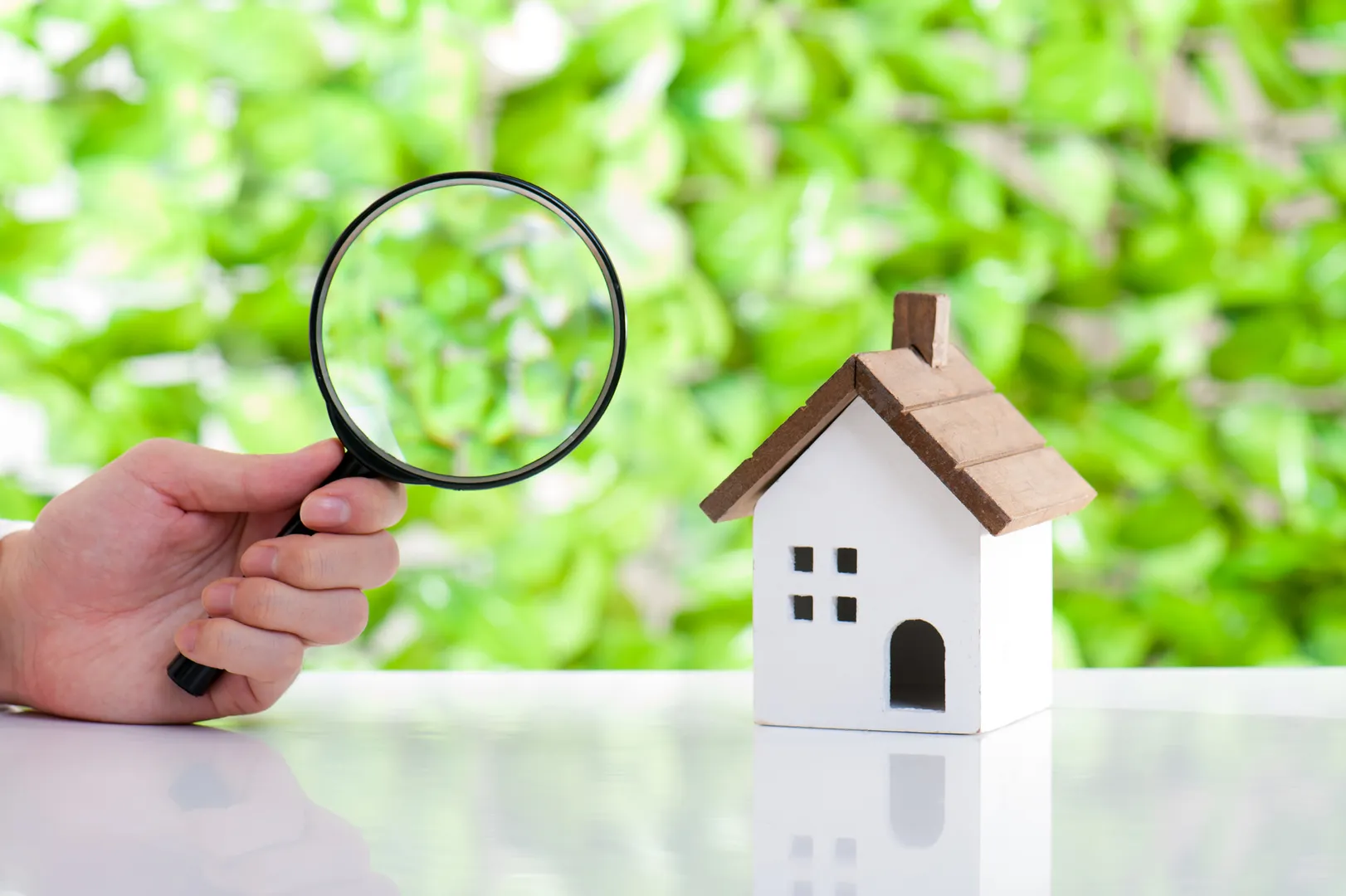 Visite immobilière : les points essentiels à vérifier avant d’acheter un bien immobilier Loupe et petite maison