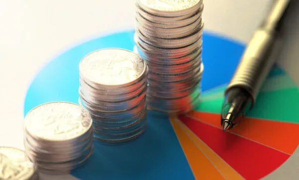 Pourquoi Choisir l'Investissement Immobilier Plutôt que la Bourse ? Pièces de monnaies, stylo et graphique