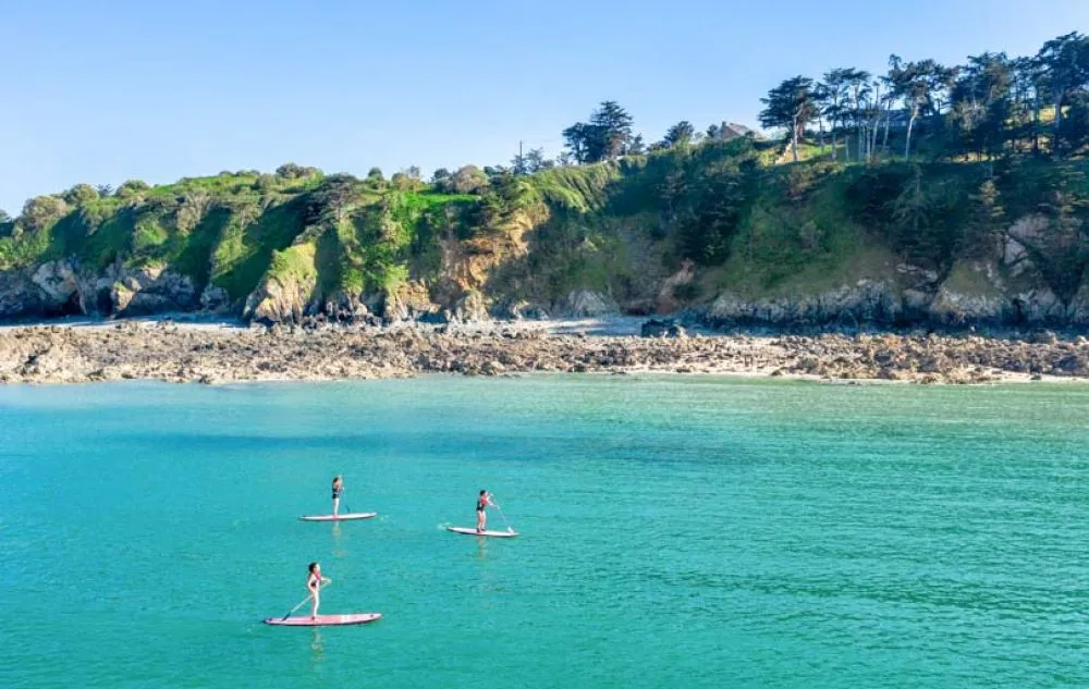Investir à Saint-Brieuc Plage, personnes sur des paddels
