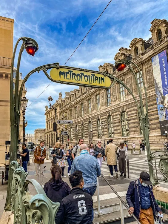 Gratuit Journée chargée à l'entrée emblématique du métro parisien avec son architecture classique et sa vie urbaine. Photos