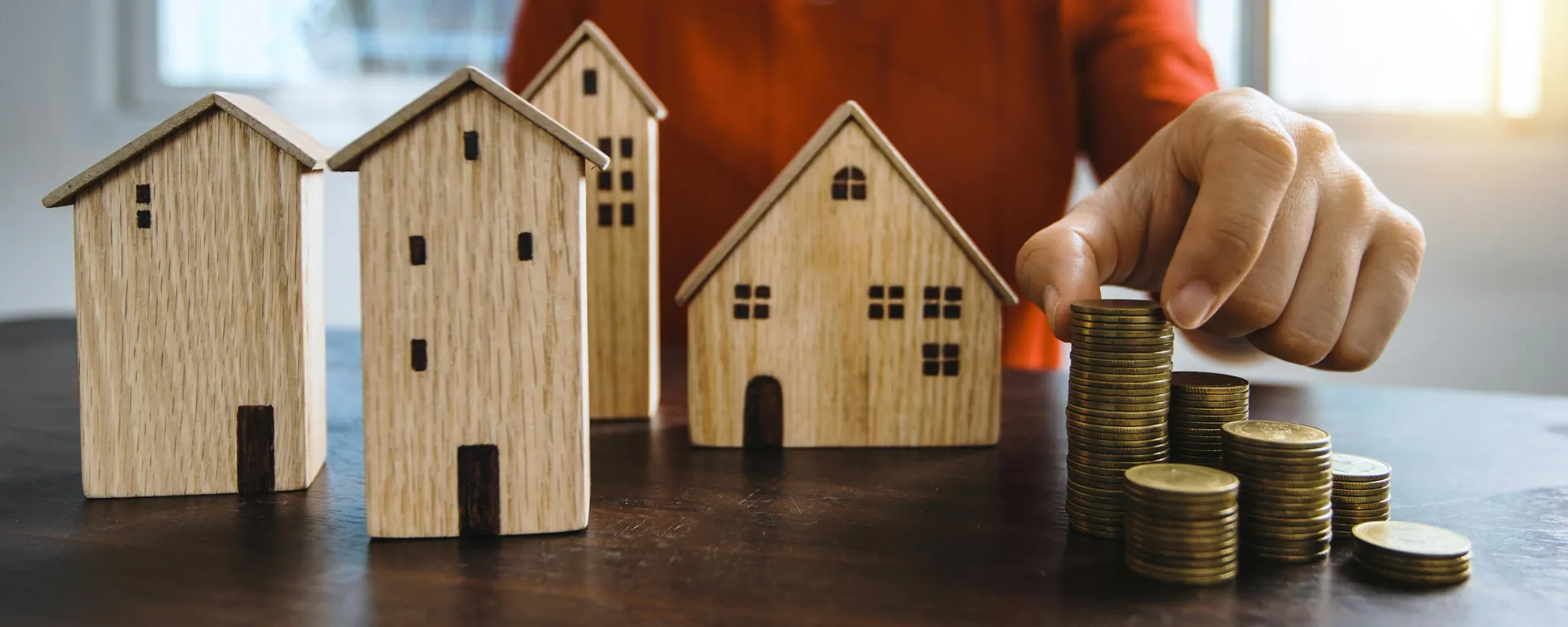 Investir dans l'immobilier jeune : conseils et stratégies gagnantes Maisons en bois et pièces de monnaies