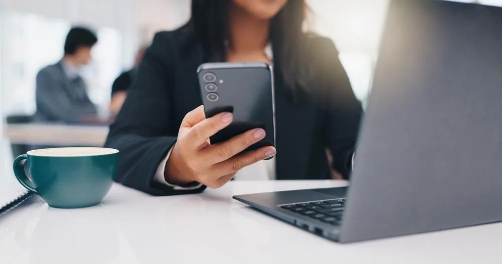 Persona pagando con el celular en un terminal de pago sin contacto