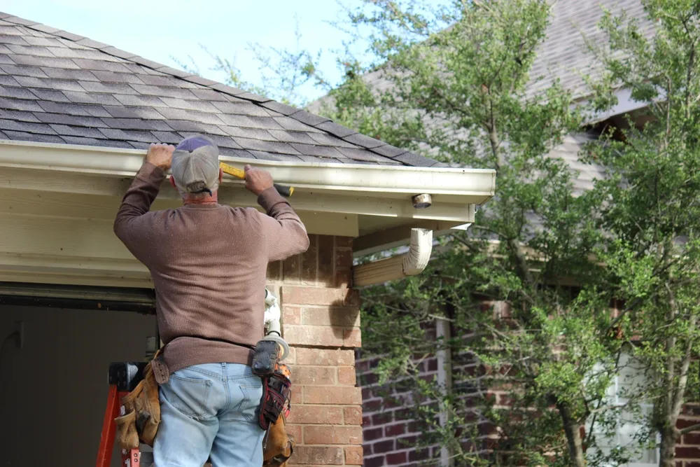 A contractor installing a new gutter system for a home