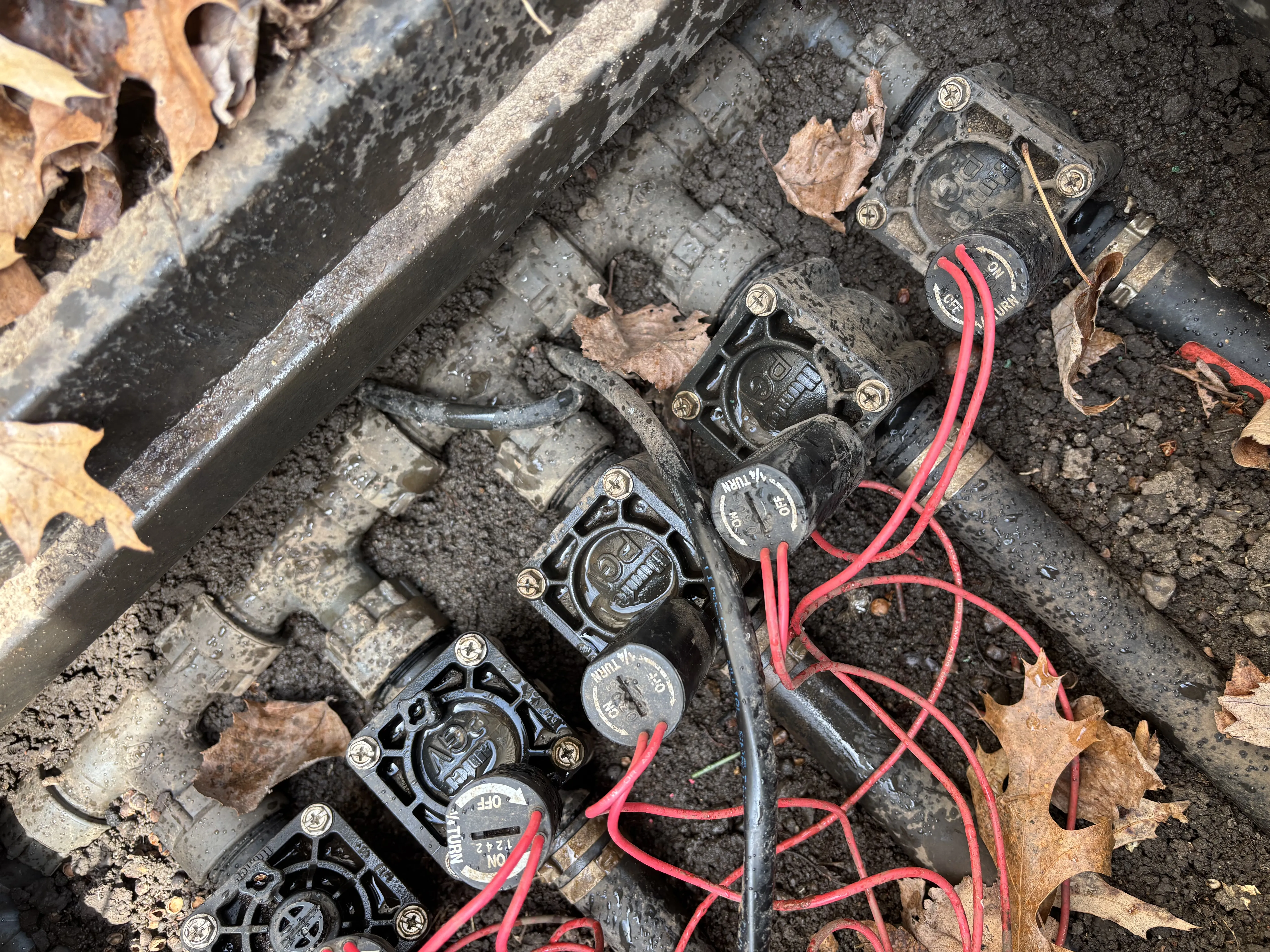 Technician repairing a sprinkler system in a Minneapolis lawn.