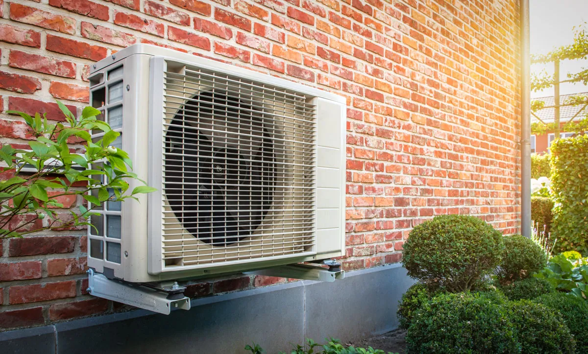 An outdoor air conditioner on a home wall. Air conditioning installation and AC repair services in New Orleans, LA.