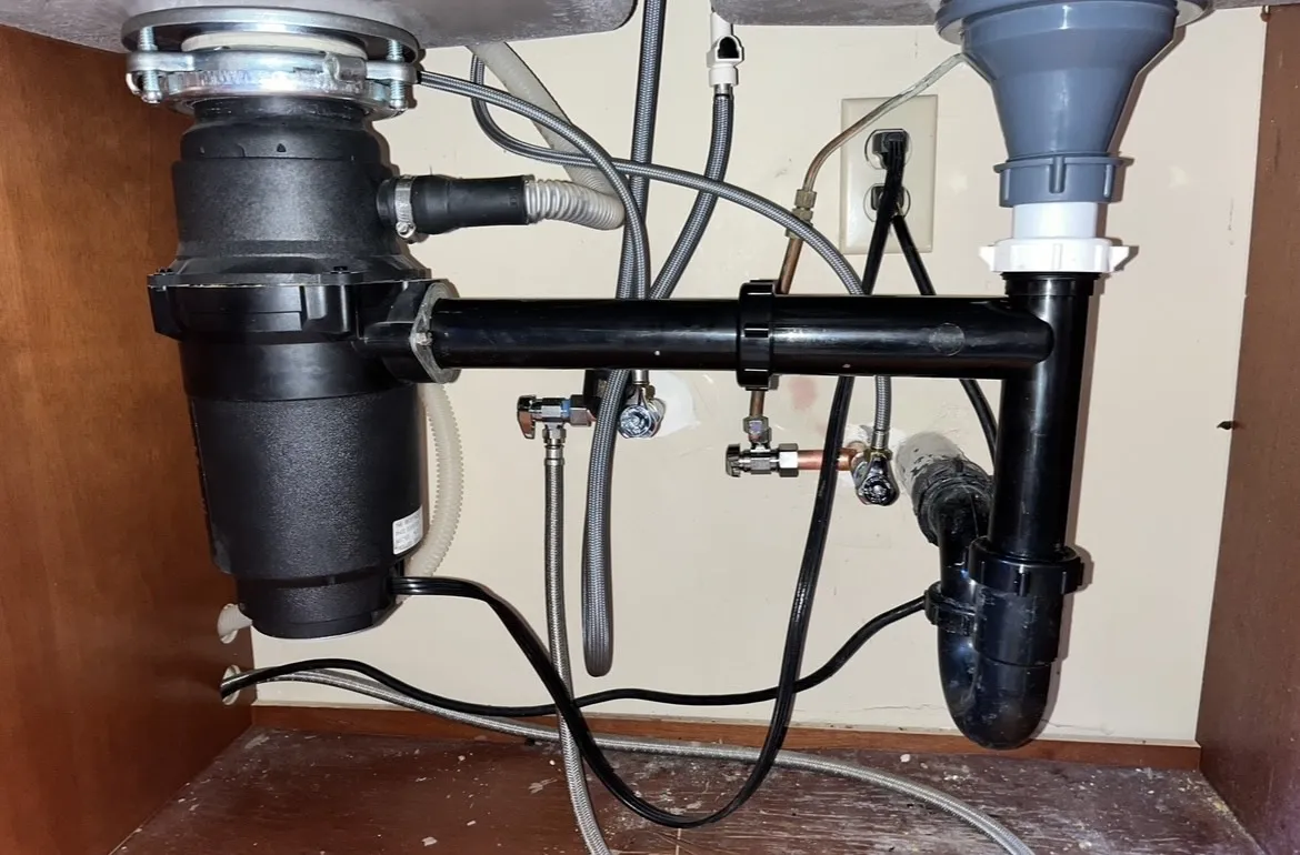 Oro Valley plumber inspecting plumbing problems under kitchen sink, repairing pipes and drainage to resolve plumbing needs in Oro Valley AZ.