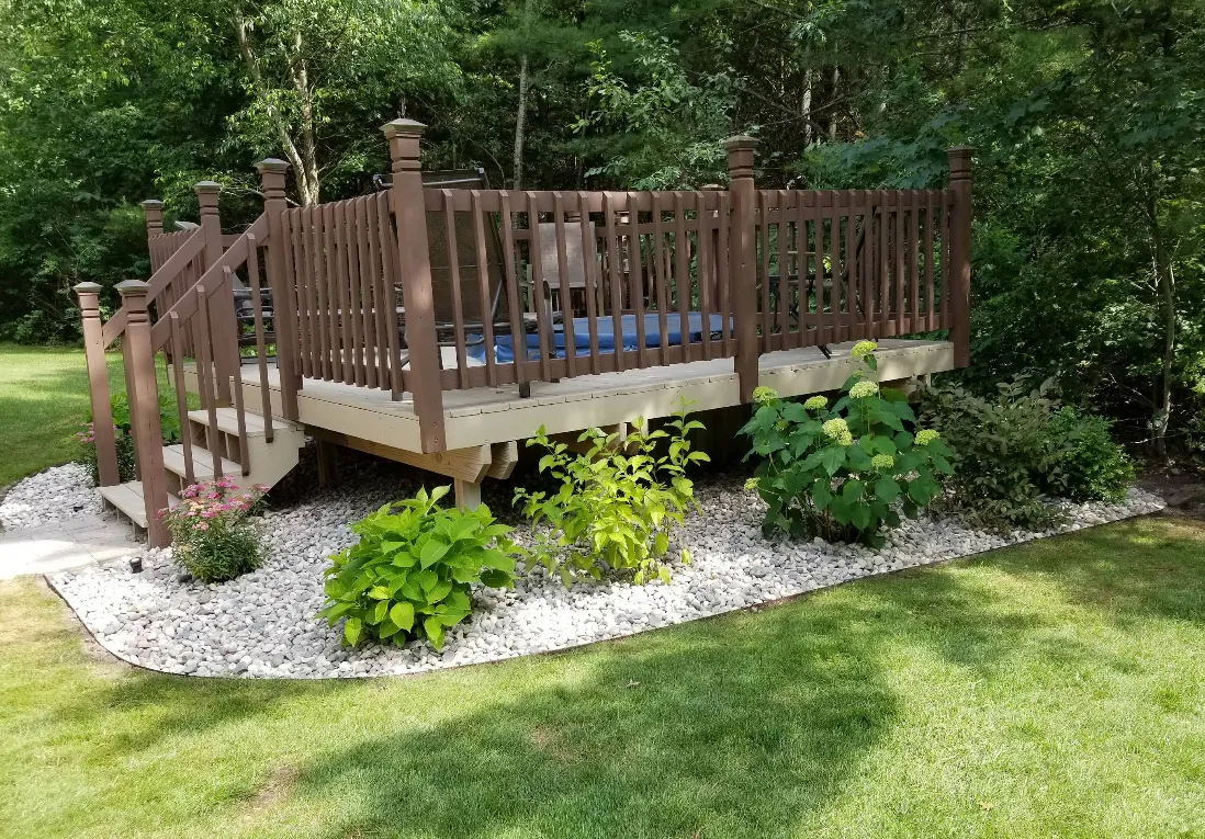 Beautiful backyard garden bed in Grand Rapids maintained by expert landscaping company, with lush lawn care, pest control, and regular lawn mowing services to boost curb appeal.