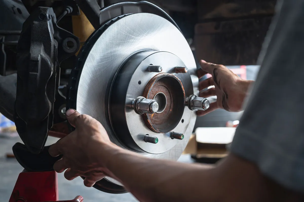 A mechanic is replacing a brake. AutoFix Center services most makes and models of vehicles and helps drivers get back on the road safely.